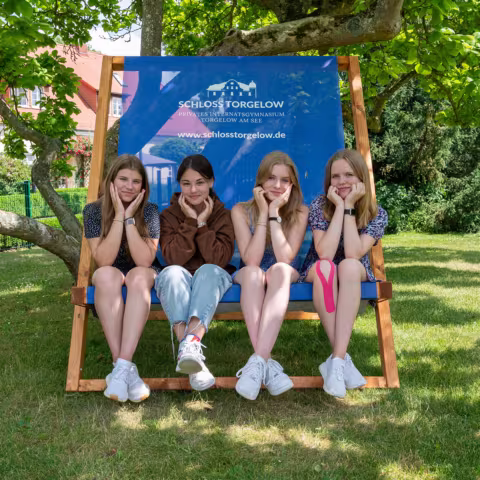 Leben im Internat und soziales Miteinander: Schülerinnen auf Bank